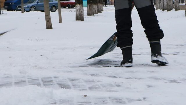 The janitorThe janitor cleans the snow with a plastic shovel cleans the snow with a plastic shovel