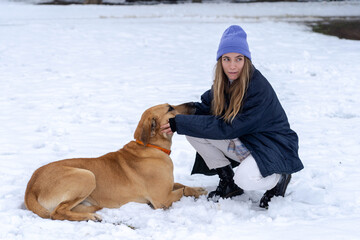 Girl with her dog in the snow