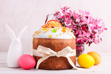 Easter cake with colored eggs and bouquet of pink flowers