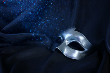 Photo of elegant and delicate Venetian mask over black silk background