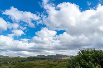 Fototapeta na wymiar Street view of transmitter tower on an agricultural field in the irish highlands by Glenties in County Donegal.