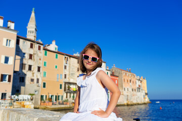 Fototapeta na wymiar Little cute girl posing on the embankment of Rovinj town, Croatia.