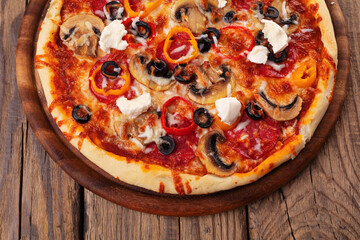 Delicious pizza served on wooden plate 