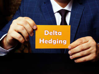 Business concept about Delta Hedging with sign on orange business card in hand.