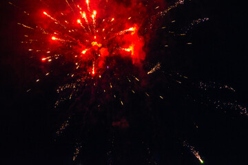 Colorful fireworks isolated on a dark background, close up, copy space. Bright red and gold sparks on a dark background. Can be used as a festive background