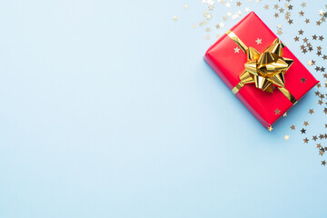 Valentine day composition, Greeting gift box with gold confetti on blue background. Flat lay.