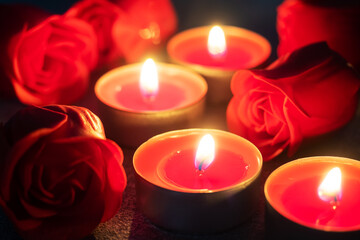 Obraz na płótnie Canvas Red roses and burning candles, close up, romantic greeting card. concept of Valentine's Day.