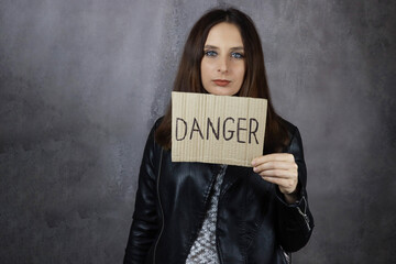 Naklejka premium Young woman showing Danger word on poster
