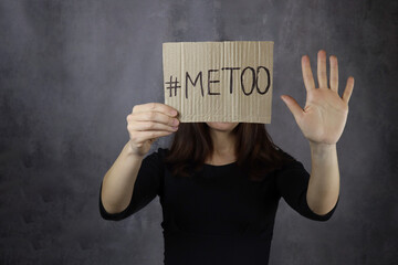 young woman covers her face with a metoo banner