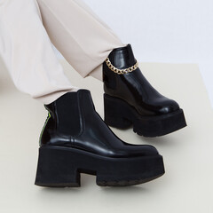 Details of trendy casual fall spring outfit. Woman in studio wearing beige trousers and stylish...