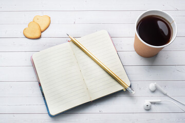 Black coffee in a paper cup and cookies in the shape of hearts on a white background. flat lay copy space, top view.