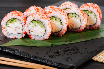 Fresh and tasty sushi rolls on black background