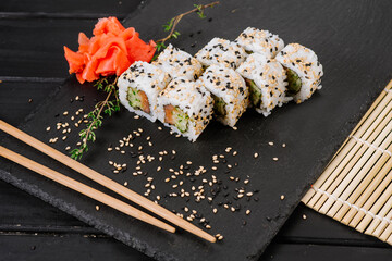 Fresh and tasty sushi rolls on black background