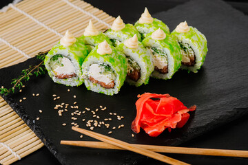 Tasty green sushi on black background