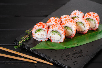 Fresh and tasty sushi rolls on black background