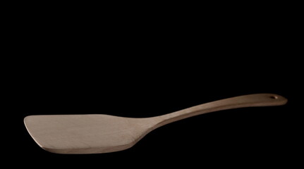 Empty wooden kitchen spatula isolated on black background with clipping path