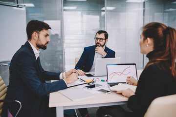 Group of coworkers having meeting in workspace