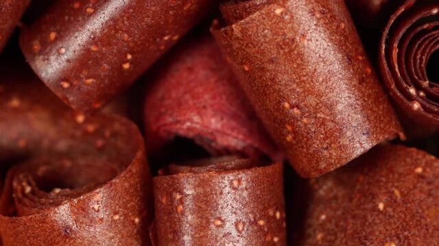 Closeup top view video of texture of mix of tastes of homemade organic fruit leather spinning around. Home cooking of healthy snacks concept.