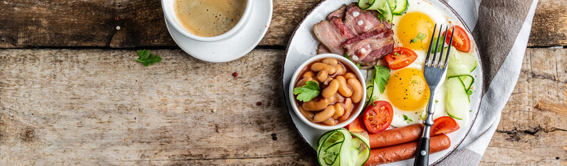 English breakfast fried egg, beans, tomatoes, bacon and coffee. Delicious breakfast or lunch. Top view, banner, overhead