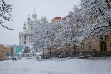 Winter cityscape with snow-covered houses, trees, cars. Heavy snowfall in the city. St. Andrew's Church. Kiev. Ukraine.