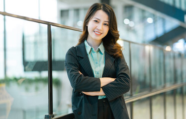 Fototapeta na wymiar Portrait of young businesswoman standing in corporate corridor