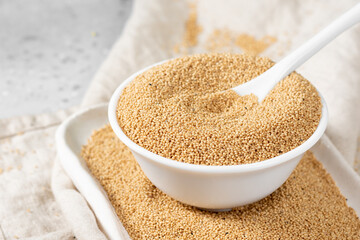 Amaranth. Amaranth seeds in a white bowl on a light gray kitchen table