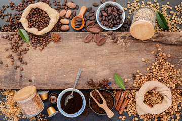 Background of various coffee , dark roasted coffee beans , ground and capsules with scoops setup on wooden background with copy space.