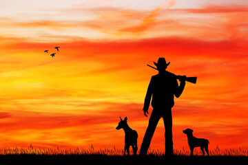 hunter with dogs at sunset