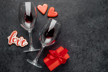 valentine's day celebration concept .glasses with wine and heart shaped cookies on stone background with copy space for your text