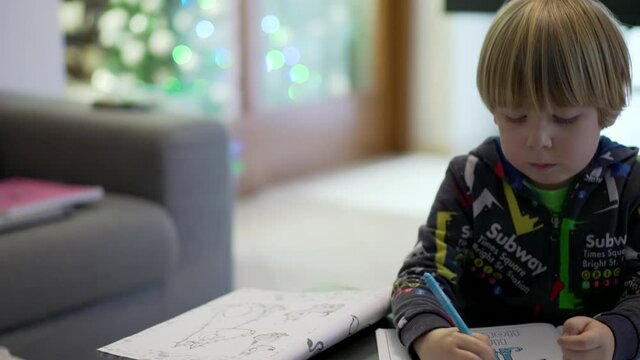 slow motion shot of a child paints a coloring book. tracking shot