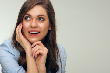 Smiling woman touching face looking away.