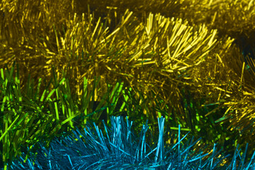 Fluffy green, yellow, gold, blue tinsel decor. Texture.