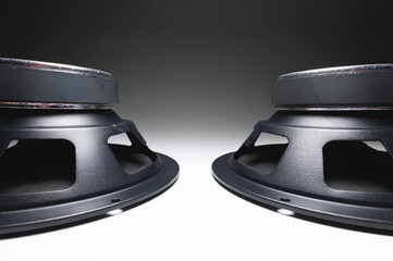 Two new car speakers on a white background in contrasting light. Wide angle audio background