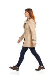 Walking Young Woman In Beige Coat, Jeans And Brown Shoes