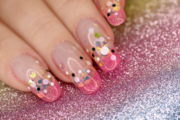 Fashionable French manicure on long rounded nails with sequins of different sizes.