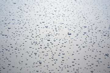 Small drops of water on a gray background.