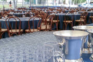 many round tables in preparetion for a lunch at a large meeting, glasses on forecast
