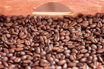 Fototapeta premium A wooden box full of roasted coffee beans.