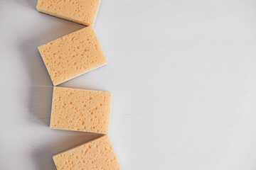 Yellow porous sponges on a white background. Top view. Copy, empty space for text