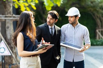 Young Executive CEO business man and woman secretary meeting with energy engineer plan a project to build a solar panel for the building under construction.