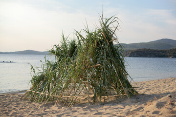 A small hut of green reeds on the beach © tchara
