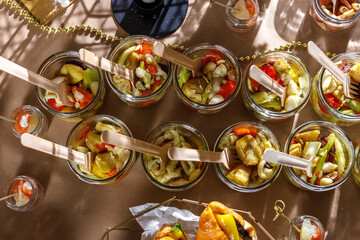 Cocktail of squid meat and seafood in glass jars with wooden forks. Eco-friendly dishes.