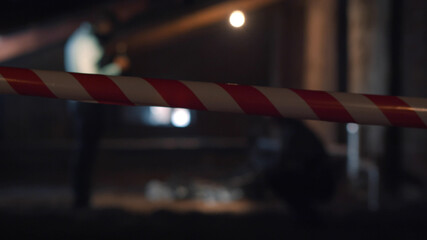 Detectives standing at crime scene near dead body on blurred background
