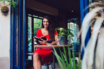 Ethnic female student with book in cafe