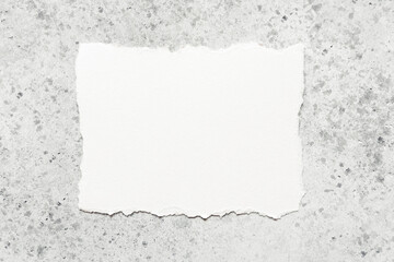 Obraz premium A blank white paper card on a gray concrete background. Place for text.