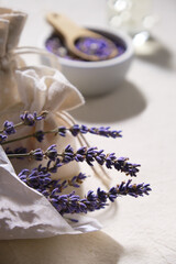 Close-up on dry lavender flowers in white tracing paper. Hand made lavender sachets in textile bags and cotton hearts on cotton tablecloth,. Low impact rustic lifestyle.
