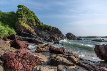 waves hit the rocks on the shore in summer