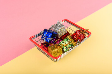  A miniature shopping basket carrying a lot of gift boxes.