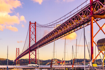 Barcas amarradas en el puerto bajo el Puente colgante 25 de abril sobre el tajo en Lisboa al...