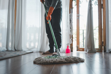 Woman  clean up the house with mop.